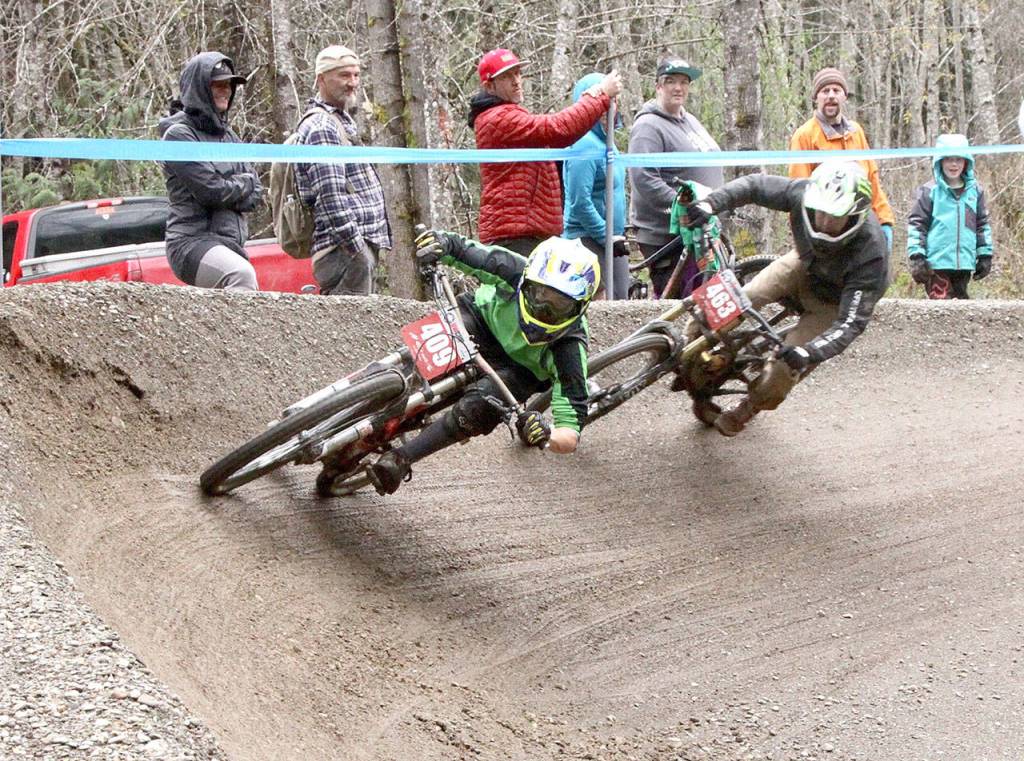 Coming into the last big corner of the race down the Dry Hill course west of Port Angeles on Sunday are Joseph Mantis of Preston (409) and Jameson Raymond of Bonney Lake (463). The two were racing in the 14 and under boys category. (Dave Logan/for Peninsula Daily News)