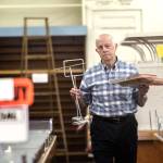 Rudy Hiener, whose daughter owns Bay Variety, walks past empty shelves as he carries items to the front of the store Monday. (Jesse Major/Peninsula Daily News)