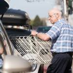 Rudy Hiener, whose daughter owns Bay Variety, carries a rack to a customers vehicle Monday. (Jesse Major/Peninsula Daily News)