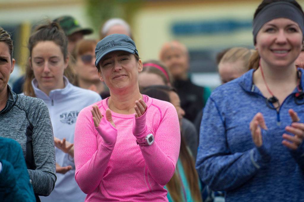 Women applaud as Carrie Sanford explains why she organized Sundays Run Without Fear. (Jesse Major/Peninsula Daily News)