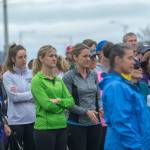 A group of mostly women listen as Carrie Sanford tells of why she organized the Run Without Fear on Sunday. (Jesse Major/Peninsula Daily News)