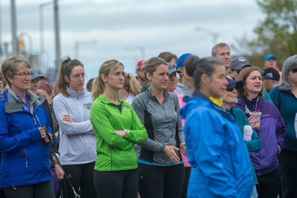 A group of mostly women listen as Carrie Sanford tells of why she organized the Run Without Fear on Sunday. (Jesse Major/Peninsula Daily News)