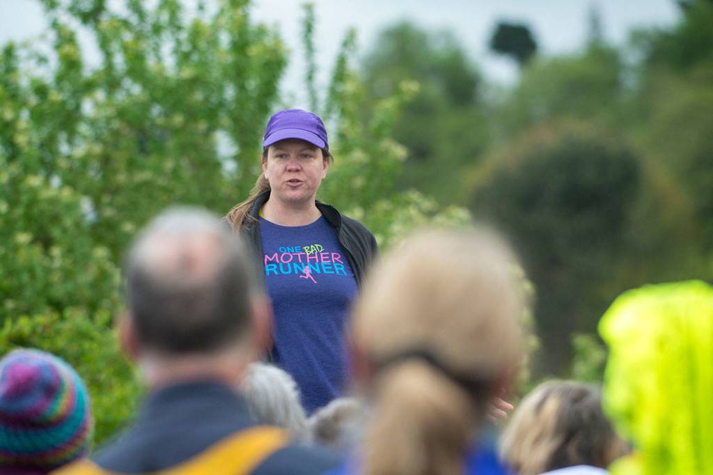 Carrie Sanford, who organized the Run Without Fear, tells participants she was angry when she heard a woman had been attacked on the Olympic Discovery Trail two weeks prior. (Jesse Major/Peninsula Daily News)