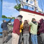 The Felicity Ann is blessed by minister/boatbuilder Simon de Voil during its launch ceremony at Point Hudson on Tuesday. The historic wooden boat was restored by the Northwest School of Wooden Boatbuilding and the Community Boat Project by volunteer craftspeople. (Jeannie McMacken/Peninsula Daily News)