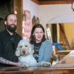 Mat Brooke, his wife, Lisa Jack, and their dog Sherman stand at the bar of The Spruce, a restaurant the couple is preparing to open in downtown Port Angeles early this summer. (Jesse Major/Peninsula Daily News)
