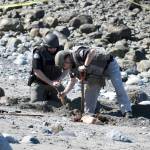 State Patrol Bomb Squad technicians Keith Nester and John Ryan process the scene at North Beach where a metal object believed to be some kind of World War II device was found Tuesday afternoon. Upon further review, it was decided the object was of an undetermined nature and a piece of it was taken to the state lab for analysis. (Jeannie McMacken/Peninsula Daily News)