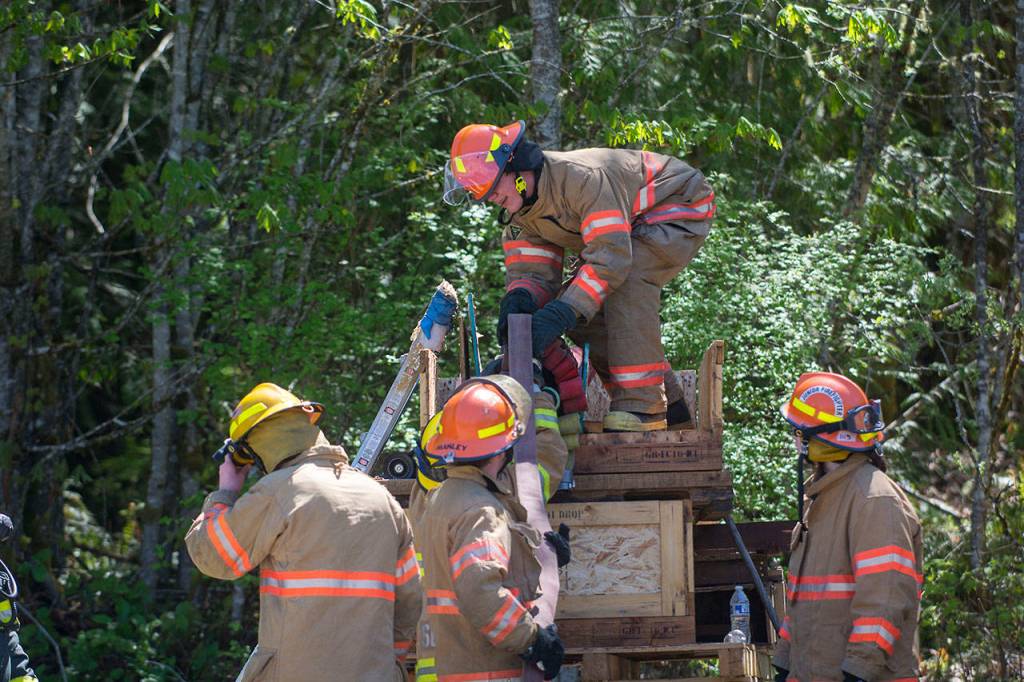 Fire explorers load hoses. (Jesse Major/Peninsula Daily News)