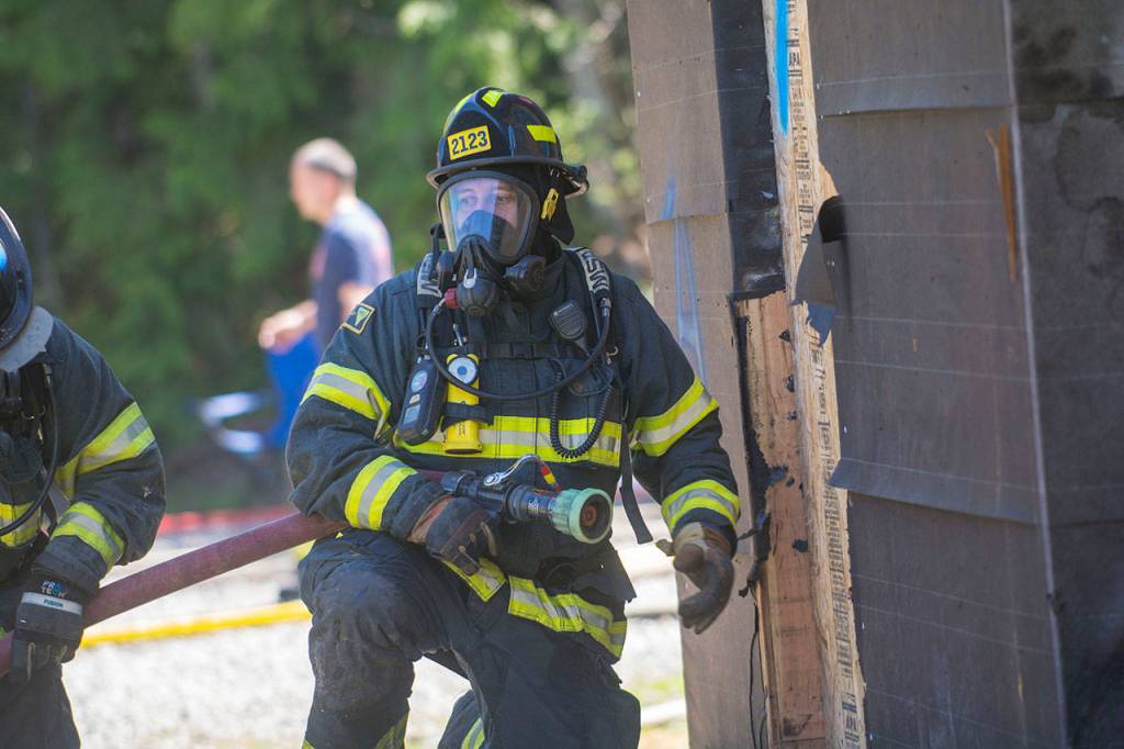 A firefighter prepares to enter the house. (Jesse Major/Peninsula Daily News)