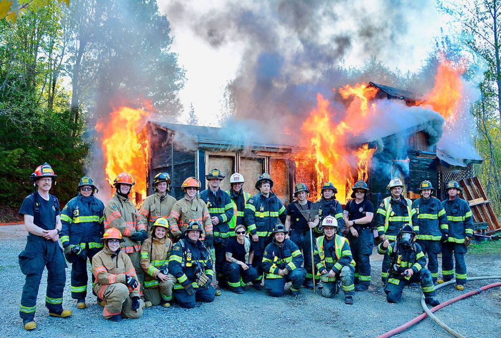 The participants in the fire training gather in front of the burning structure. (Jay Cline/Clallam County Fire District No. 2)