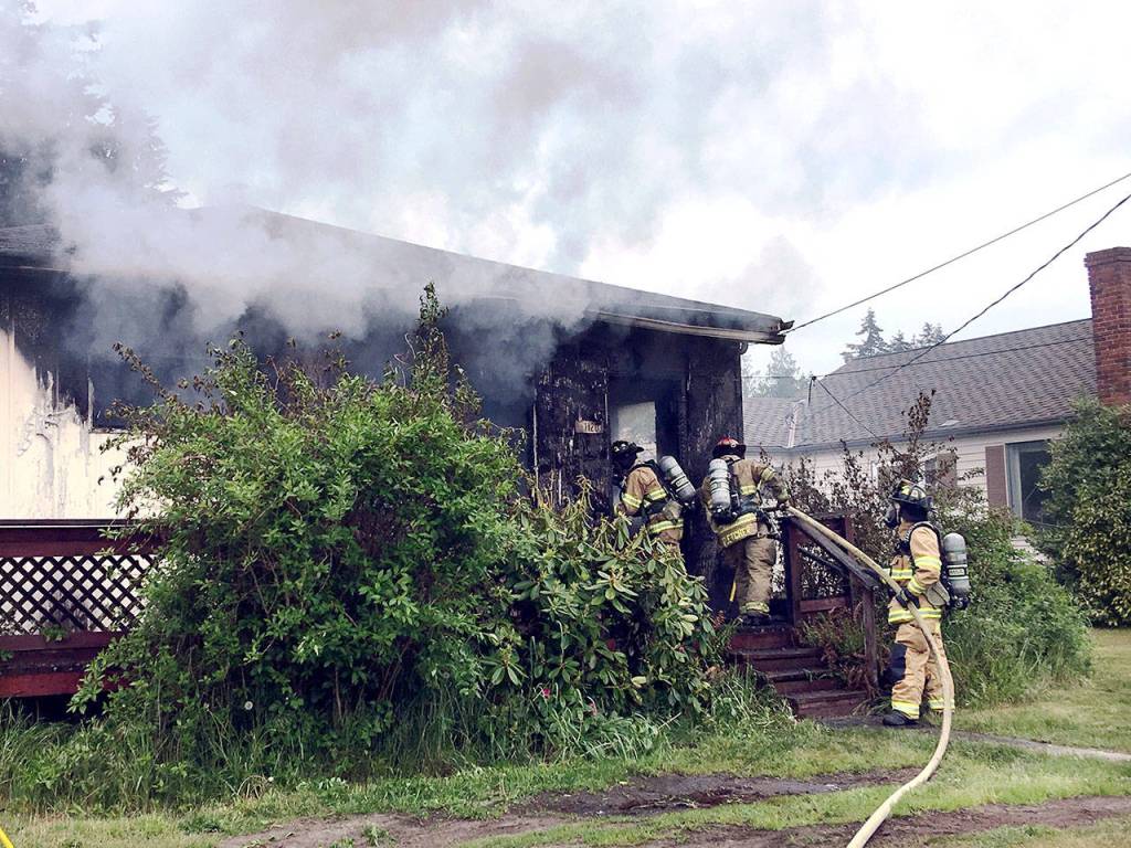 East Jefferson Fire-Rescue firefighters attack a blaze that burned a home in Port Ludlow. (East Jefferson Fire-Rescue)