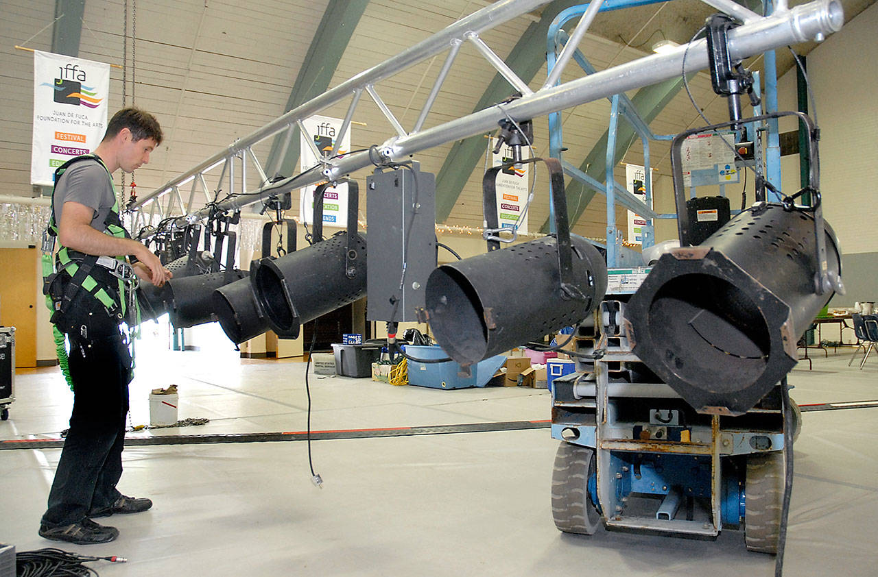 Luke Kehrwald of Seattle-based Performance Sound configures a rack of suspended spotlights Thursday in the Vern Burton Community Center in preparation for this weekends Juan de Fuca Festival of the Arts in Port Angeles. (Keith Thorpe/Peninsula Daily News)