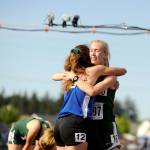 1,600-meter state champion Gracie Long of Port Angeles, right, and second-place finisher Kristen Garcia hug after Long beat Garcia by 0.37 of a second to take first place. At left is Port Angeles Maddie Dougherty, who finished 11th in the race. (Michael Dashiell/Olympic Peninsula News Group)