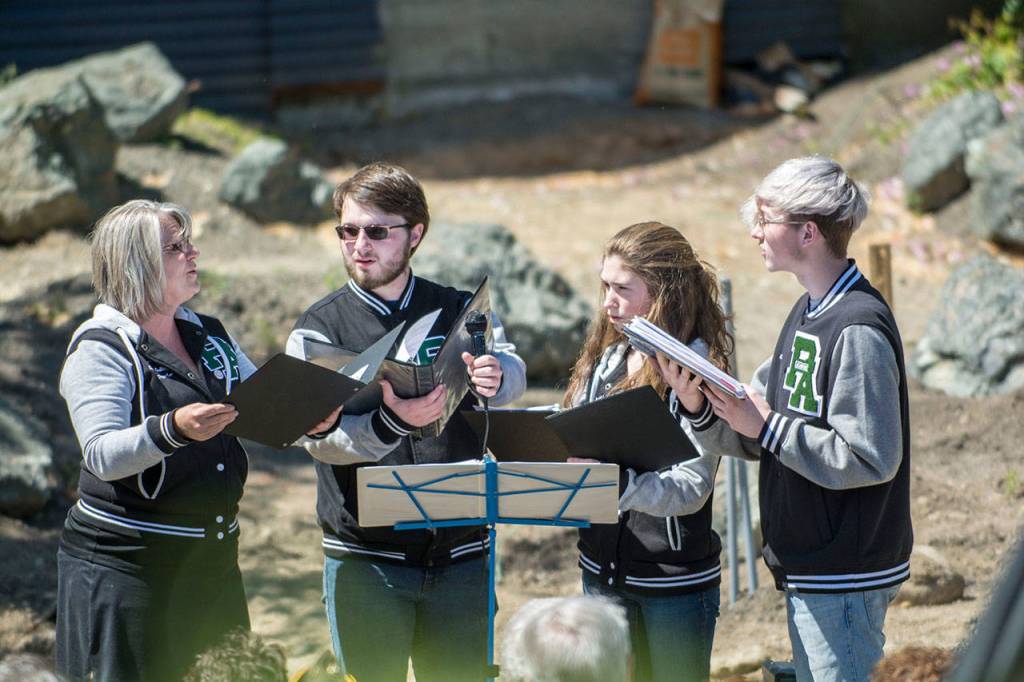 From left, Port Angeles High School choir teacher Jolene Dalton Gailey, senior Owen Nevaril, senior Sienna Porter and junior Ethan Cameron, sing America is Beautiful during the Captain Joseph House Memorial Service on Sunday. (Jesse Major/Peninsula Daily News)
