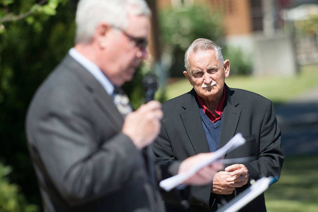 Joe Borden, vice president of the Captain Joseph House board, watches on as volunteer Tom Cox speaks during the Captain Joseph House Memorial service Sunday. (Jesse Major/Peninsula Daily News)
