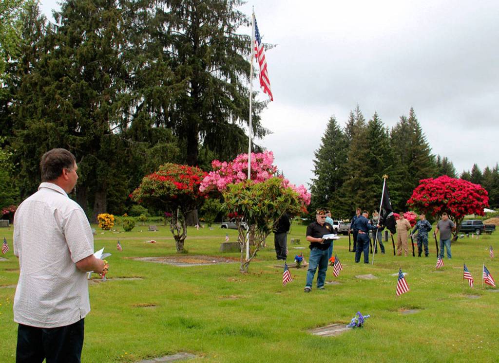 Forks Mayor Tim Fletcher, left, prepares to speak at the Memorial Day ceremony at the Forks Cemetery on Monday. Fletcher-Wittenborn VFW Post 9106 Commander Tom Hughes welcomed the roughly 60 people who attended the event. Fletcher, VFW Auxiliary President Janet Hughes and Tom Hughes each offered a short speech. Rod Fleck, city attorney/planner, read General John A. Logans Memorial Day Order from 1868. Fleck also lowered the city flags to half mast. Pastor Tom Lafrenz offered the invocation and benediction. Local members of the VFW and American Legion Post 106 provided the rifle volley. (Christi Baron/Olympic Peninsula News Group)