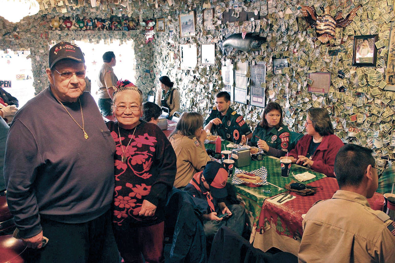 Carl and Miyo (Mickey) Schmidt threw in a batch of Smittys famous burgers for the volunteer workers as they collected a cache of dollar bills put up on Fat Smittys walls in January 2012. (Olympic Peninsula News Group)