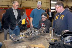 Keith Thorpe/Peninsula Daily News Washington Gov. Jay Inslee, left, examines a steampunk-themed metal artwork created by Peninsula College welding students, from left, Ellis Henderson of Port Townsend, and Nathan Hofer and Matthew Weaver of Port Angeles during the governors tour of the colleges welding class on the Port Angeles campus on Thursday. The shop tour was part of a presentation on economic opportunities and partnerships in the maritime industries on the North Olympic Peninsula.