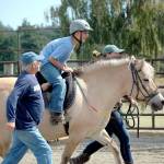 Gabriel Hernandez, 14, of Seattle rides Tikki while volunteers Glenn Reedy, foreground, and Cat Grindall stick close by. (Candace Raab)