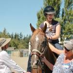 Salish Spirit volunteers help Molly Ciaciuch, 18, of Port Angeles as she learns to ride with confidence. (Candace Raab)