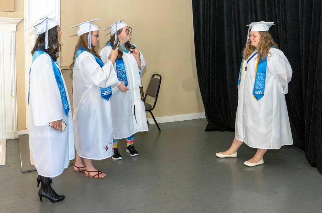 Soon-to-be graduates, from left, Gladys Hitt, Christina Bell, Emily Calkins and Natalie Carlson, take turns taking pictures while waiting for the 2018 Chimacum High School commencement to begin Saturday at McCurday Pavilion at Fort Worden State Park. (Steve Mullensky/for Peninsula Daily News)