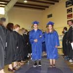 The 15 graduates of Crescent High School march into the gym Saturday with the familiar music of Pomp and Circumstance. Leading the parade through a smiling gauntlet of Crescent school teachers are seniors salutatorian Kyle Buchanan and valedictorian Cecily Clark. (Dave Logan/for Peninsula Daily News)