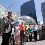 Shankar Narayan, legislative director of the ACLU of Washington, left, speaks at a news conference outside Amazon headquarters Monday in Seattle. (Elaine Thompson/The Associated Press)