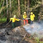 Firefighters Sarah Springob, from left, Tyler Gear and Zach Gear mop up a fire Sunday evening on state Department of Natural Resources land west of Port Angeles. (Clallam County Fire District No. 2)