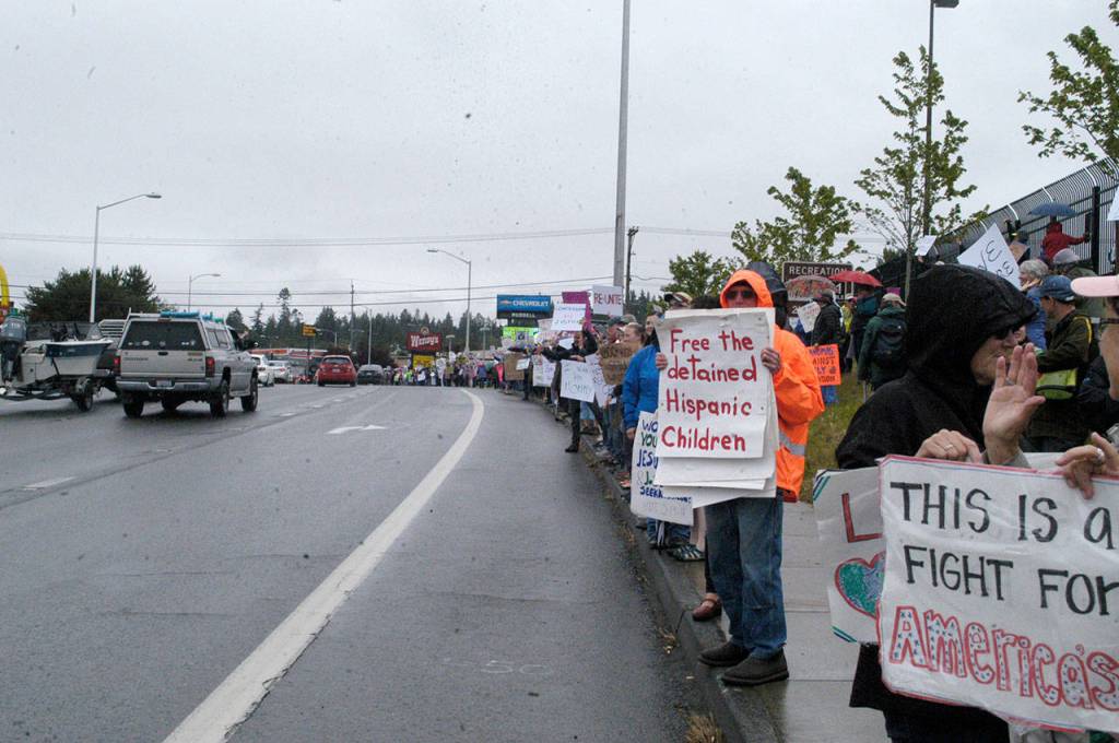Protesters gather for a Families Belong Together rally near the U.S. Border Patrol building in Port Angeles on Saturday. Similar rallies were taking place across the country to protest federal immigration policies. (Rob Ollikainen/Peninsula Daily News)