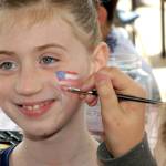 Ten-year-old Makenzy Thompson of Port Angeles receives an American Flag from face painter Abby Sanford in honor of Independence Day at the childrens activity area in the pavillion at The Gateway transit center in Port Angeles on Wednesday. (Keith Thorpe/Peninsula Daily News)