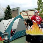 Sharon Oppenheimer sits in a camping scene on a float sponsored by Habitat for Humanity of Clallam County during Wednesdays parade in Port Angeles. (Keith Thorpe/Peninsula Daily News)