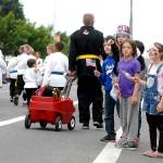 Parade-goers, from left, David Warwiuck, 8, Summer Sellers, 9, Gracie Shabel, 10, and Chloe Warwick, 7, watch the Port Angeles Independence Day parade as a contingent from Phoenix Dragon Martial Arts Hapkido & Fitness pass by Wednesday. (Keith Thorpe/Peninsula Daily News)