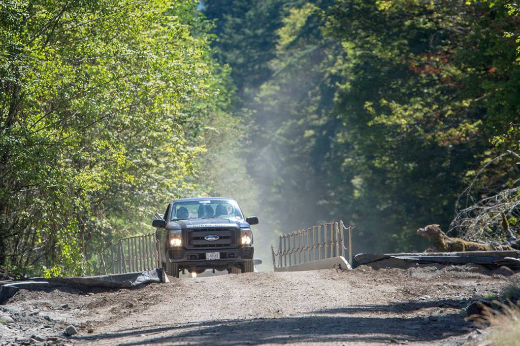 Olympic National Park workers cross the new temporary bridge that spans the Elwha River on Olympic Hot Springs Road. (Jesse Major/Peninsula Daily News)