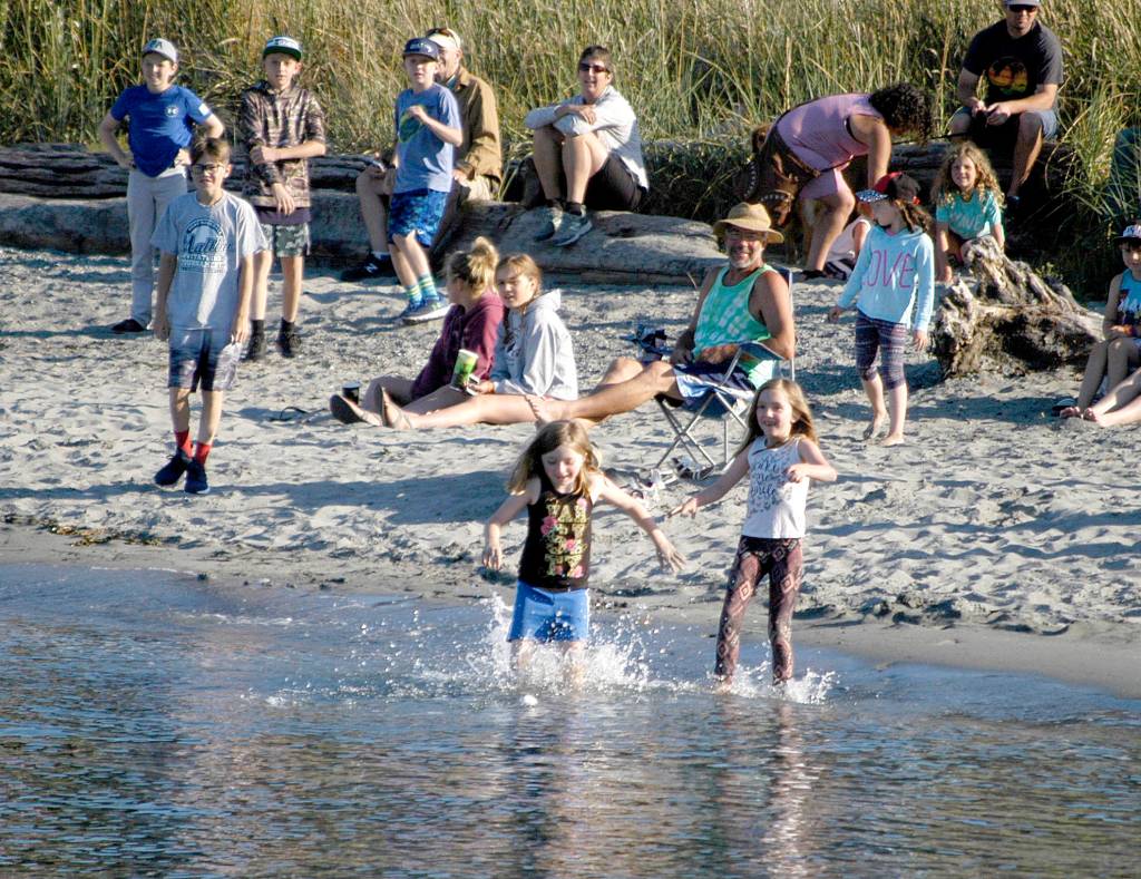 Kids on Hollywood Beach scramble to grab a foul ball during the home run derby. (Pierre LaBossiere/Peninsula Daily News)
