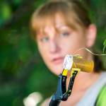 Reagan Mead, who organized a cleanup of central Port Angeles, holds up a pill bottle that she found while cleaning near Lincoln Street on Sunday. (Jesse Major/Peninsula Daily News)