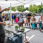 Steve Mullensky/for Peninsula Daily News Arron Stark, executive chef for Jefferson Healthcare in Port Townsend, holds up the peel from a cucumber while giving pointers for cooking healthy foods to kids and adults at the Jefferson County Farmers market on Wednesday. Stark demonstrated the making of a healthy dip for a crudite using fresh peas and cottage cheese as part of World Wide Breast Feeding Week with the emphasis on breast milk as the very first healthy food kids get in life. The program was sponsored by Jefferson Healthcare and Jefferson County Public Health. The demos will repeat on Saturday at the Uptown Farmers Market.