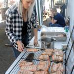 Lauren Hartley prepares salmon planks during a salmon bake hosted by the Crescent Bay Lions Club at the Joyce Daze Wild Blackberry Festival. (Keith Thorpe/Peninsula Daily News)