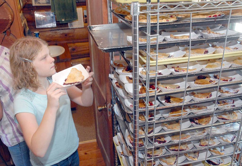 Emmaly Wood of Joyce, 10, arranges slices of blackberry pie for sale to the public during Saturdays Joyce Daze Wild Blackberry Festival in Joyce. The money raised from the sale of hundreds of slices of pie go into a scholarship fund for Crescent School graduating seniors. (Keith Thorpe/Peninsula Daily News)