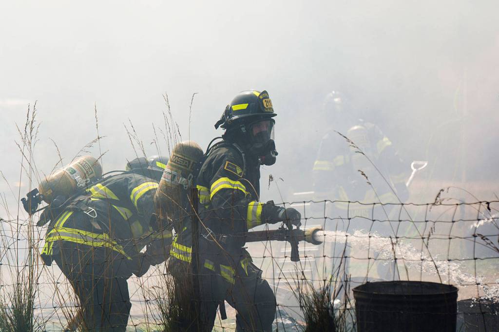 Firefighters battle an RV and shed fire on the 2300 block of East Fifth Avenue in Port Angeles on Sunday. (Jesse Major/Peninsula Daily News)