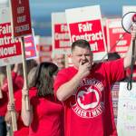 Port Angeles Education Assocation President Eric Pickens leads hundreds of teachers and their supporters as they march toward the Port Angeles School District Central Services building on Thursday. (Jesse Major/Peninsula Daily News)
