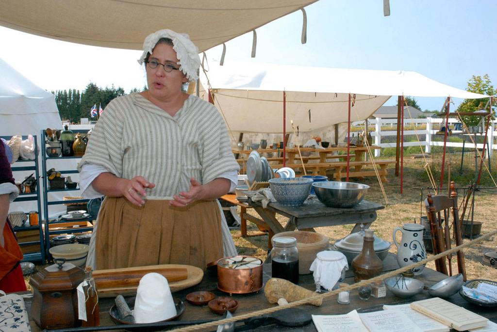 Stephanie Lindley of Lacey talks about cooking during the Revolutionary War era at a colonial kitchen set up at the Northwest Colonial Festival near Agnew. (Keith Thorpe/Peninsula Daily News)