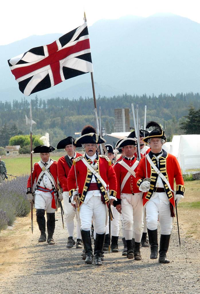 A cadre of Revolutionary War reenactors in the guise of British soldiers marches to battle at the Northwest Colonial Festival on Friday near Agnew. (Keith Thorpe/Peninsula Daily News)