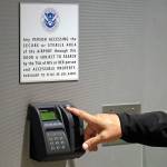 A worker at Seattle-Tacoma International Airport places his finger on a biometric screening device before entering a secured area of the airport Monday. (Elaine Thompson/The Associated Press)