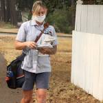 Jennifer Wendell of the United States Postal Service walks her rounds on South Ennis Street in Port Angeles on Monday morning with a for breathing amid the smoky air. (Dave Logan/for Peninsula Daily News)