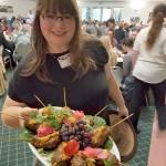 Event volunteer Magdalene Adenau serving locally sourced lamb kofta with romesco at the Harvest Dinner 2017. (Alana Linderoth/North Olympic Land Trust)