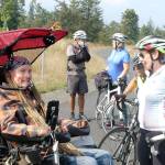 Ian Mackay and his supporters stop to celebrate after crossing the Clallam-Jefferson County line on the Olympic Discovery Trail at Diamond Point Road on Friday. Mackay had traveled on his wheelchair from Coeur dAlene, Idaho to highlight the need for wheelchair-accessible trails in Washington. (Rob Ollikainen/Peninsula Daily News)