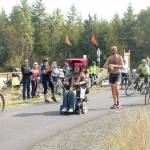 Ian Mackay and his supporters stop to celebrate after crossing the Clallam-Jefferson County line on the Olympic Discovery Trail at Diamond Point Road on Friday. Mackay had traveled on his wheelchair from Coeur dAlene, Idaho to highlight the need for wheelchair-accessible trails in Washington. (Rob Ollikainen/Peninsula Daily News)
