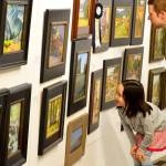 Audrey Sunwoo Dalton, 5, and her father, Toby Dalton, admire some of the award winners in the Paint the Peninsula display at the Port Angeles Fine Arts Center on Saturday. Toby, who grew up in Port Angeles, lives in Arlington, Va.; he brought Audrey to visit her grandmother Anne Dalton, an organizer of Paint the Peninsula. (Diane Urbani de la Paz/for Peninsula Daily News)