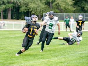 Steve Mullensky/for Peninsula Daily News Quilcenes Olin Reynolds breaks around Mary M Knights Austin Nelson for a first down during the Rangers 54-38 win Saturday.