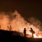 Firefighters keep watch over the Holy Fire burning in the Cleveland National Forest in Lake Elsinore, Calif., on Aug. 9. (Ringo H.W. Chiu/The Associated Press)