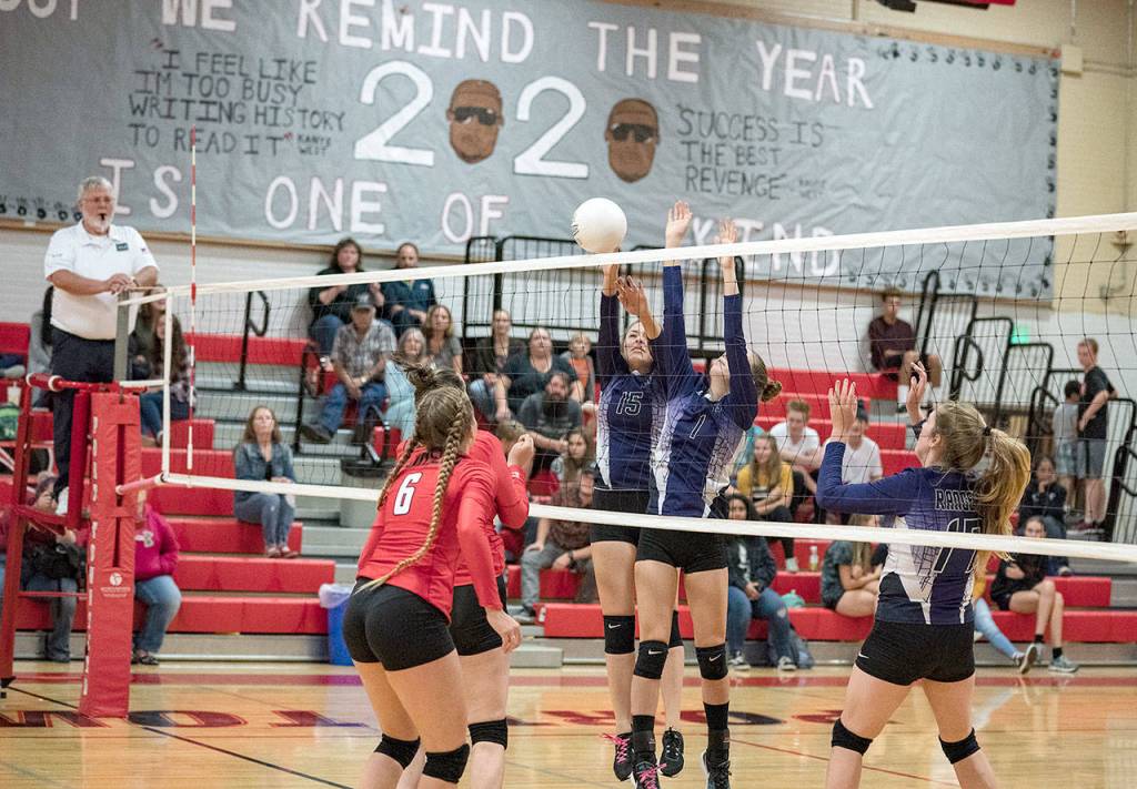 Steve Mullensky/for Peninsula Daily News Quilcenes Pearl Munn, 15, and Katie Love, 1, block a shot from the Port Townsend Redhawks during a game on Friday in Port Townsend. Marissa Kieffer, 17, is poised to assist in the play and Lady Redhawk Abiigal Kithcart, 6, watches the action unfold.